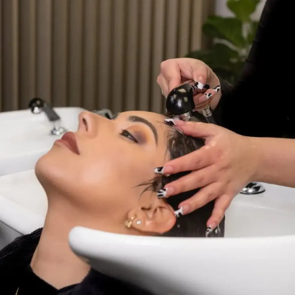 Clienta mostrando la dimensión y el brillo de su nuevo balayage, un resultado logrado por los estilistas en Santiago