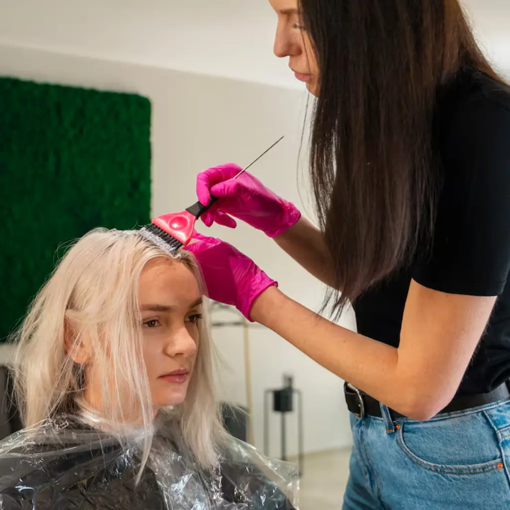 Mujer de espalda mostrando el resultado de un balayage rubio profesional, con ondas suaves y cabello brillante, realizado por los especialistas de Pro Colorist.